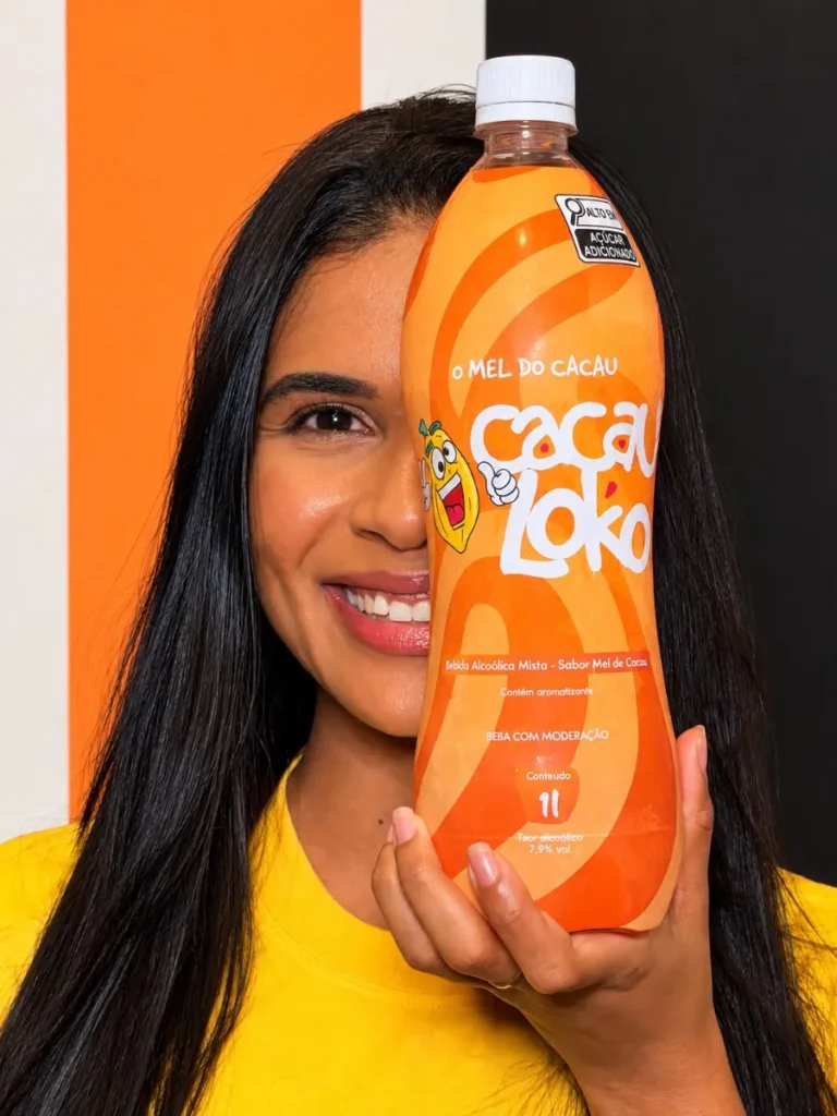Mulher sorrindo segurando a garrafa de Cacau Loko diante do rosto